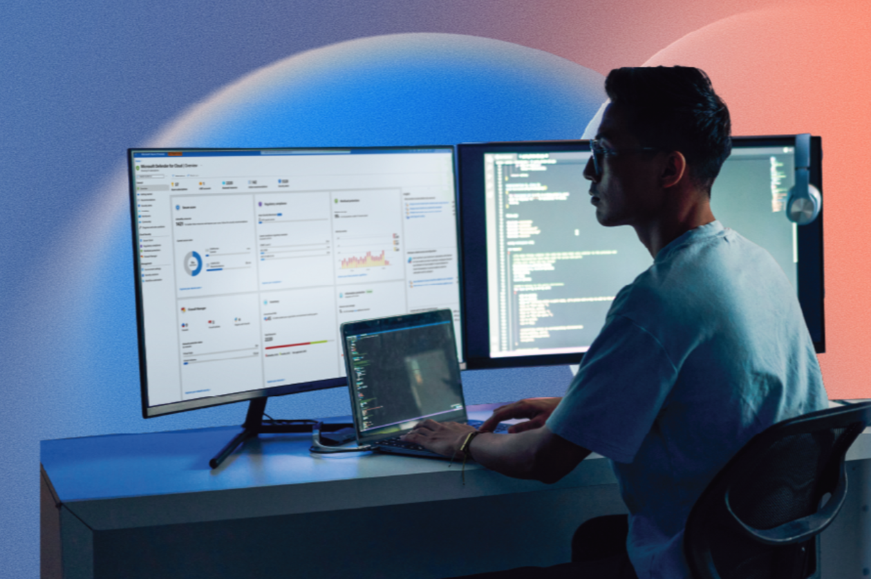 A man sitting at a desk with two computer screens