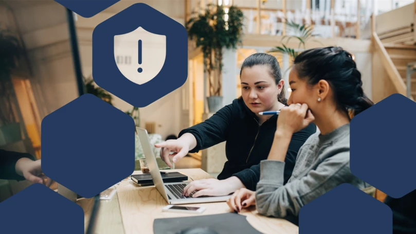 Photo of two coworkers collaborating in front of a laptop