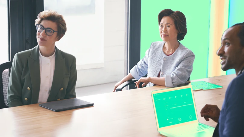 Two women sitting at a conference table.