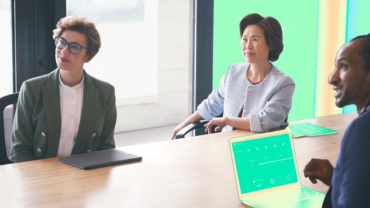 Two women sitting at a conference table.