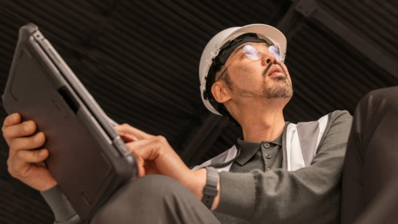 Electric car engineer in focused work on factory floor.