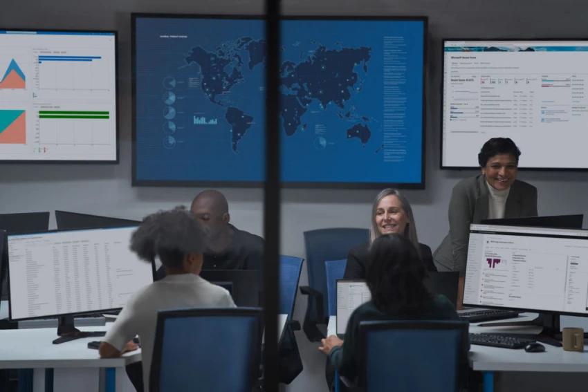 People sitting in a board room looking at computers