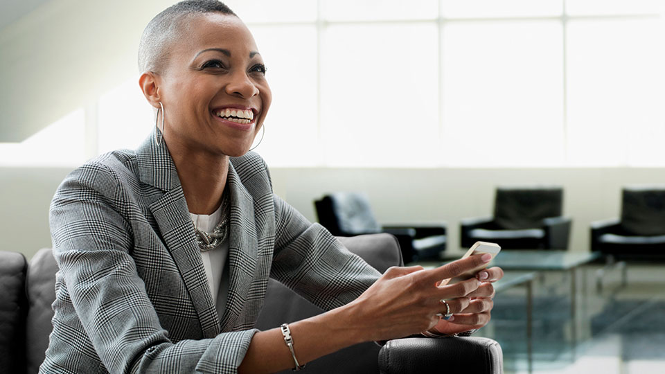 A smiling woman holding a phone