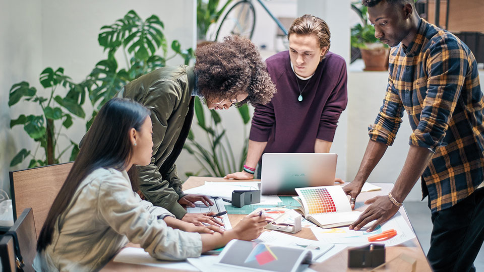Teammates work together around a conference table