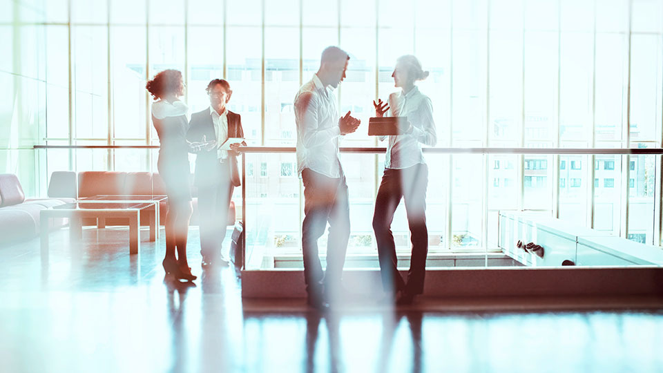 An abstracted view of people conversing in an office lobby