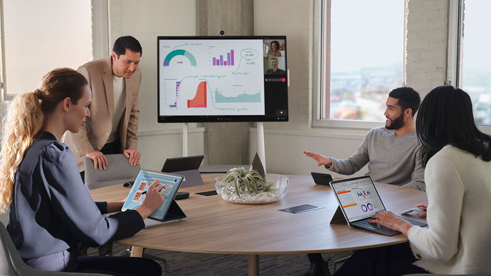 Coworkers sit around a conference table engaged in a video call
