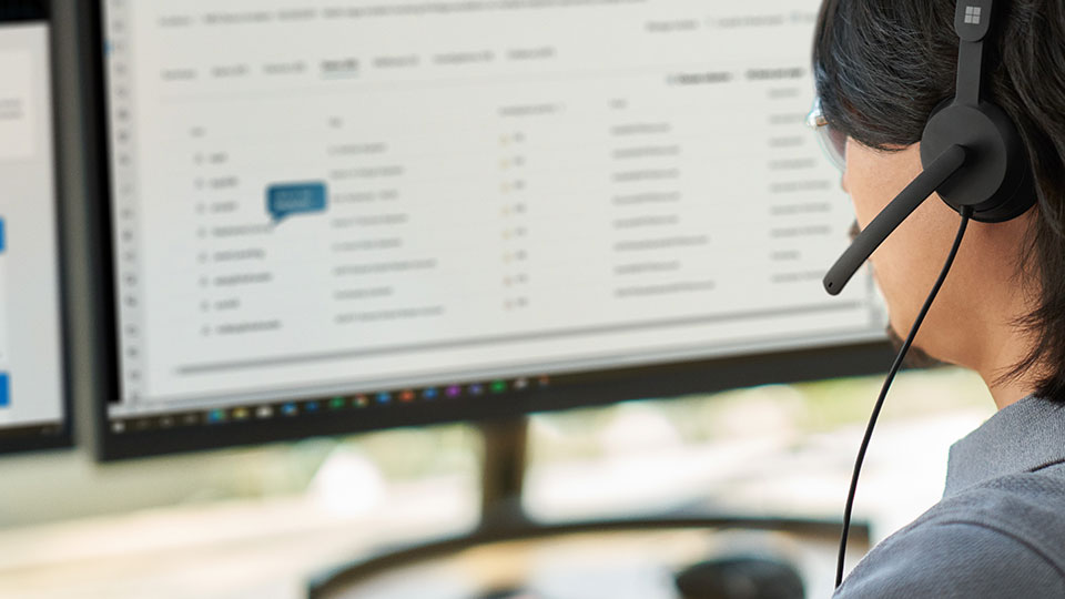 A man in a headset works at a computer workstation
