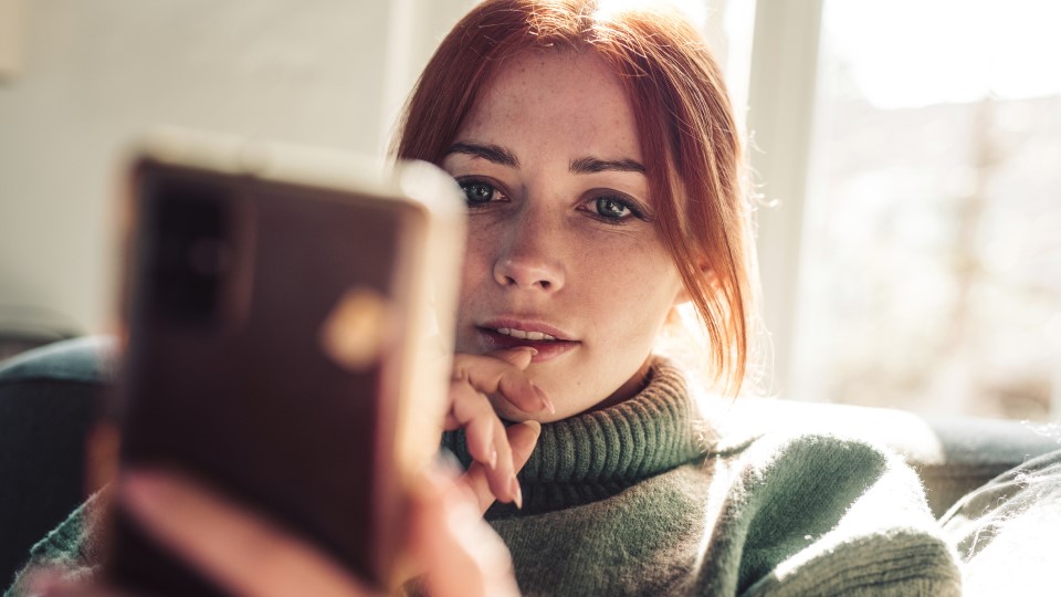 A woman looks at her phone.