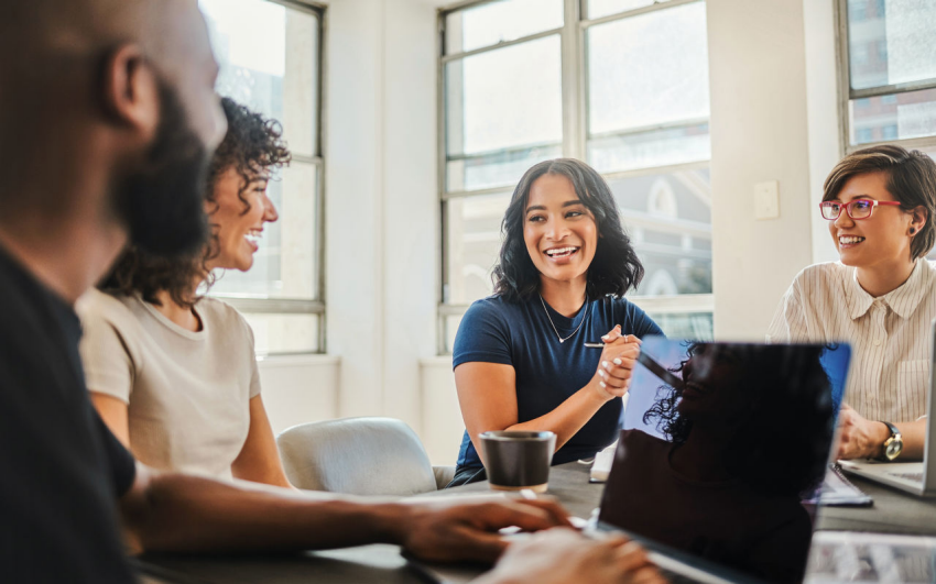 People smiling by a computer