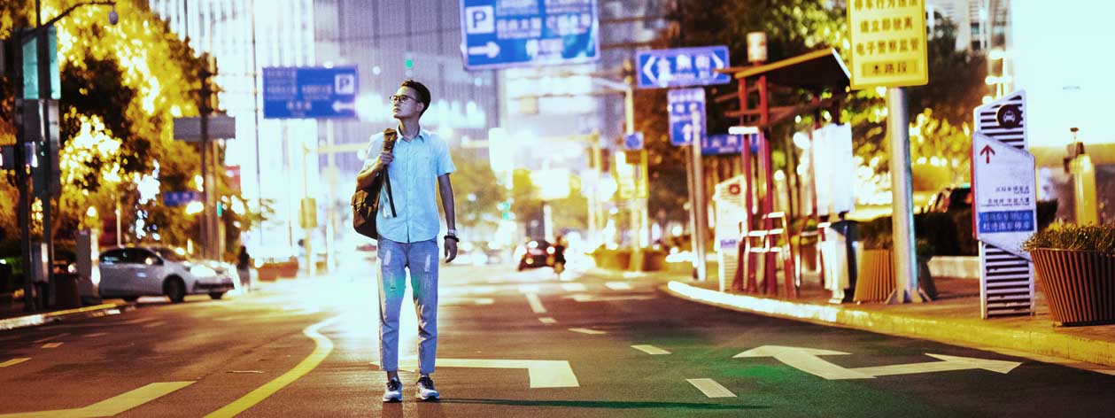 Man standing in the middle of street at night