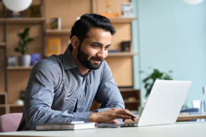 A man sitting at a desk with a laptop