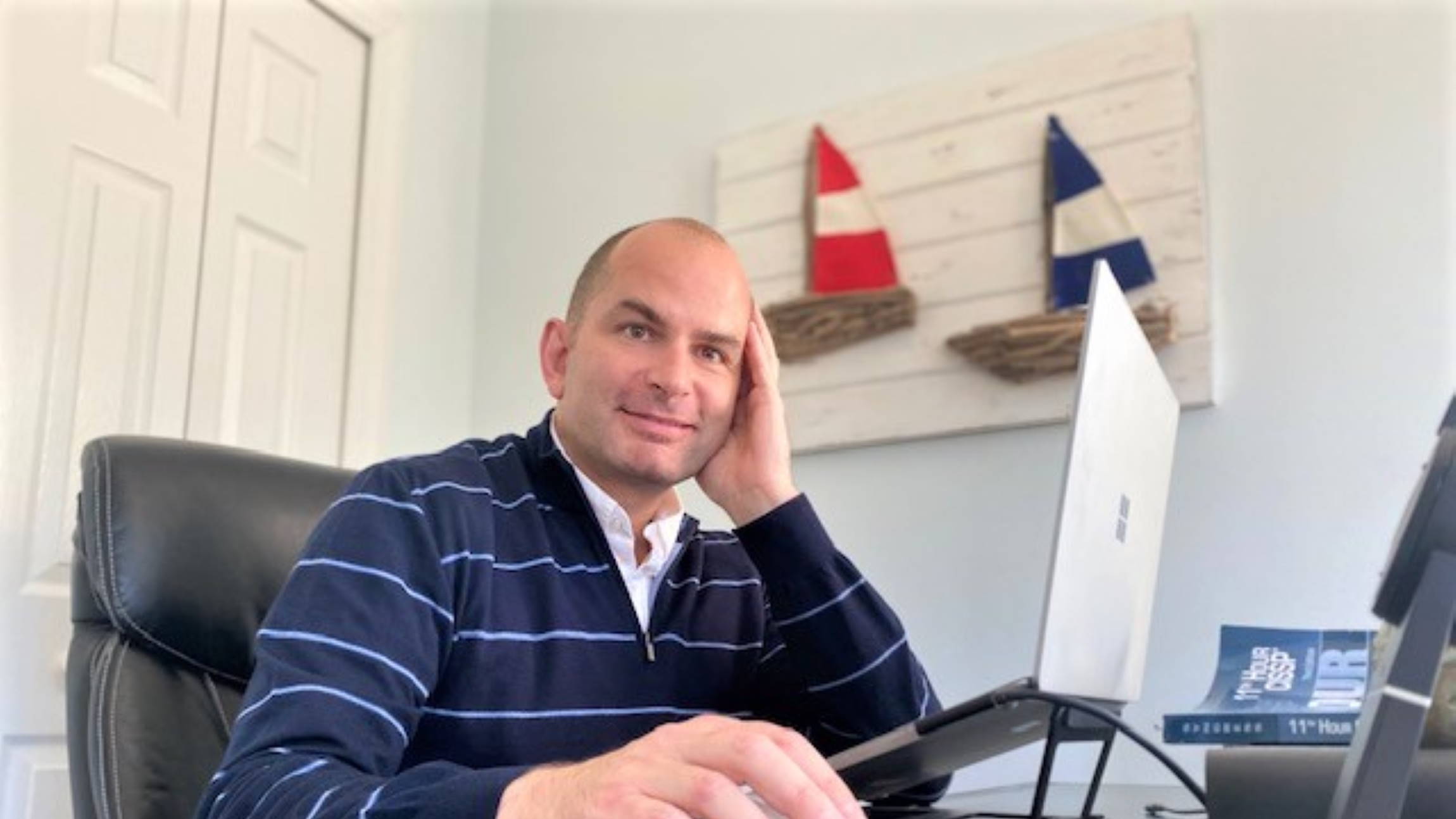 Scott Kovach sits at his desk in his home office working on his laptop.