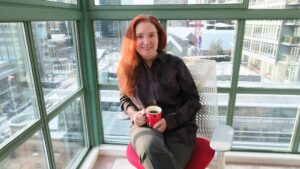 Briggs sits outside on a bench and smiles at the camera.