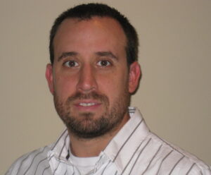 MacDonald smiles in a corporate photo.