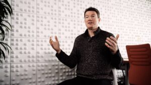 Hempey gestures with his hands up as he speaks in a Microsoft conference room.