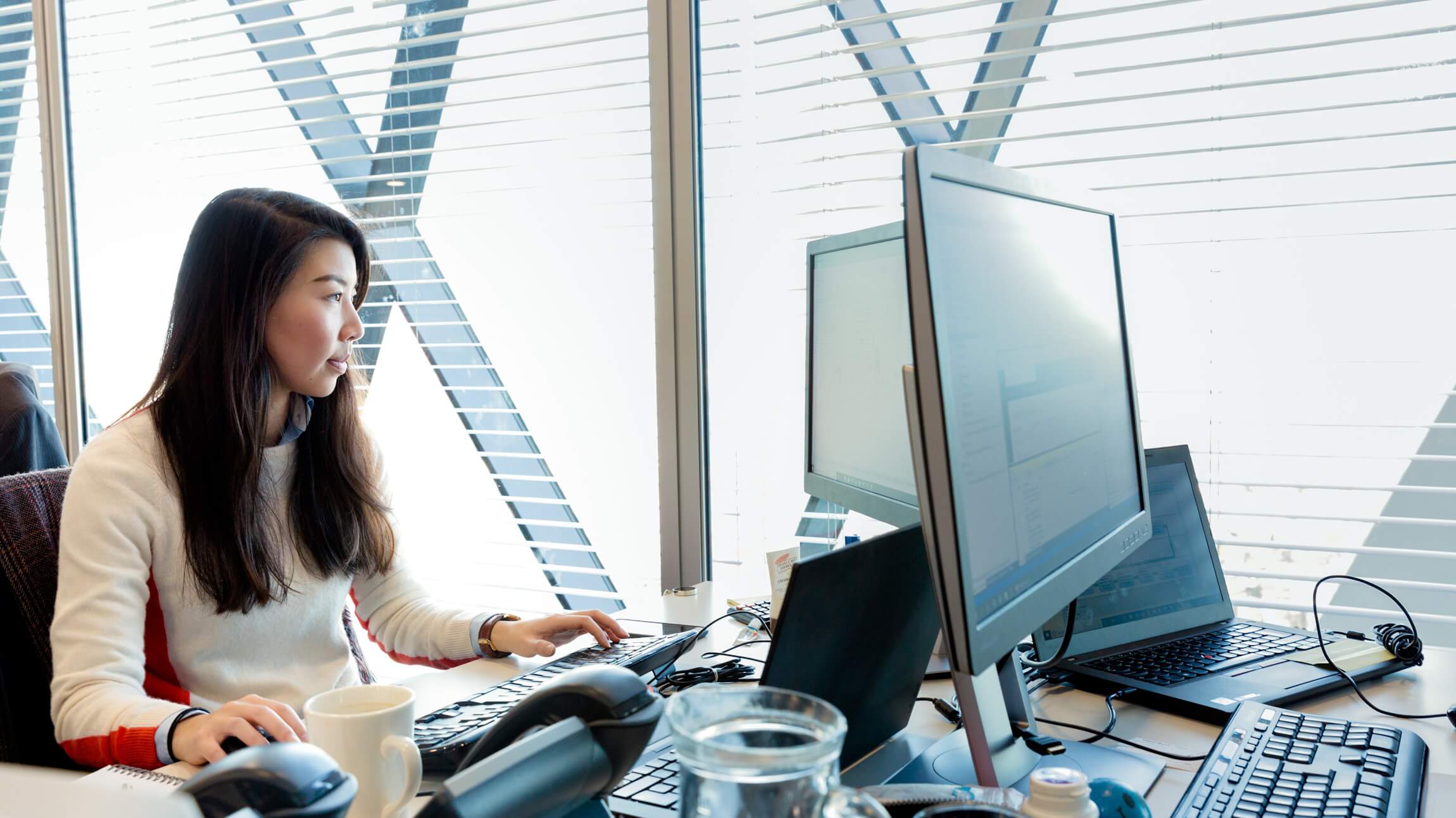 A Microsoft employee works at her desk in an open space working arrangement.