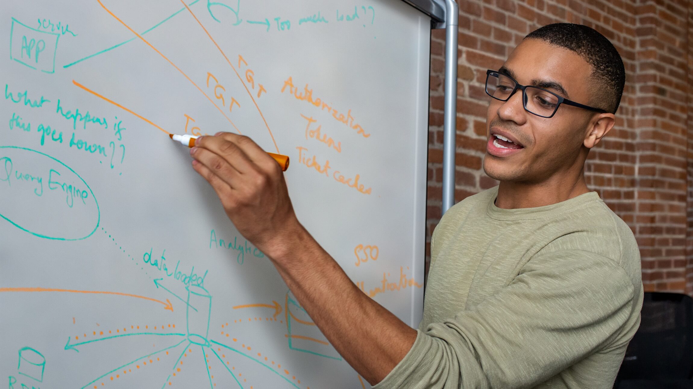 A Microsoft employee writes on a whiteboard in a Microsoft office.