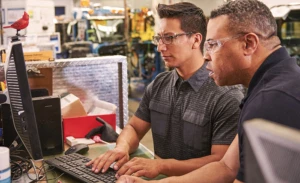 モニターで製造ラインを確認する 2 人の男性