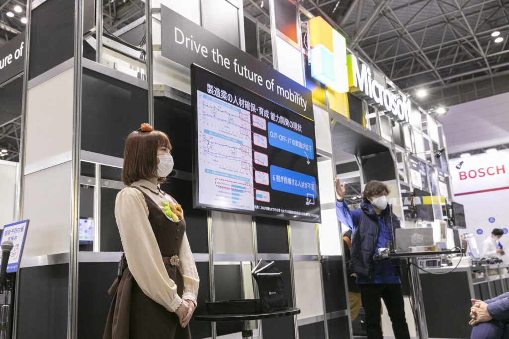 マイクロソフトブースにてセミナーを行う男性とMCの女性