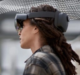 製造現場で複合現実デバイスの Hololens 2 を装着し、左側を向いている若い女性の頭部
