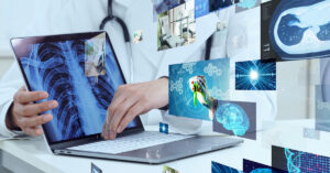 レントゲン画像を映したラップトップに触れる医師