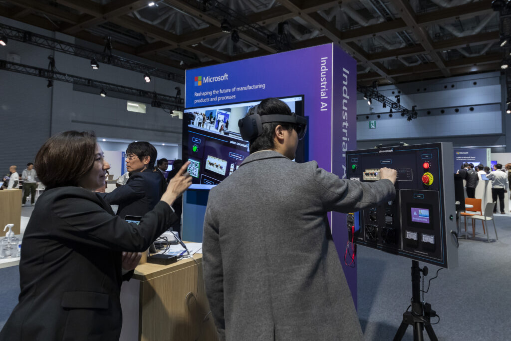 製造ブースで HoloLens 2 による現場の疑似体験をする来場者