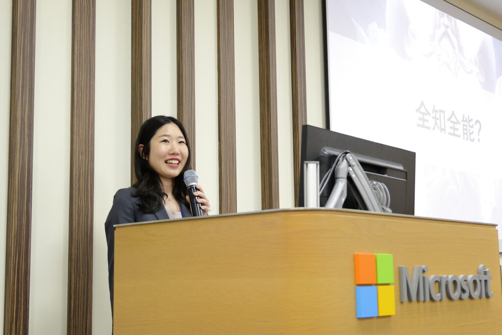 A woman standing at a podium with a microphone