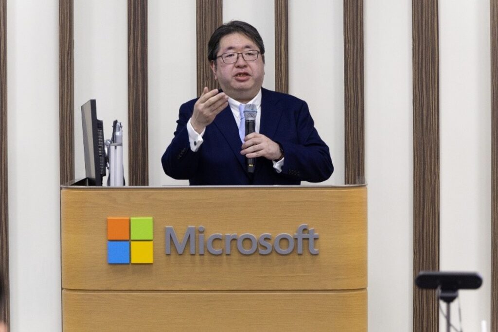 A man in a suit speaking into a microphone