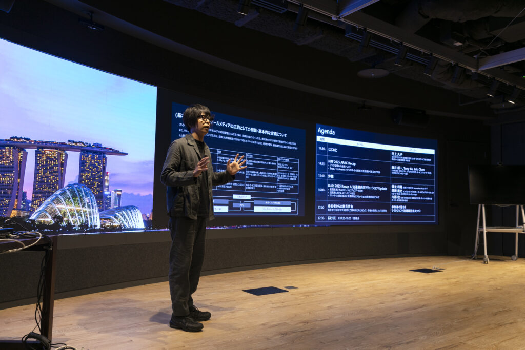 A man standing in front of a large screen