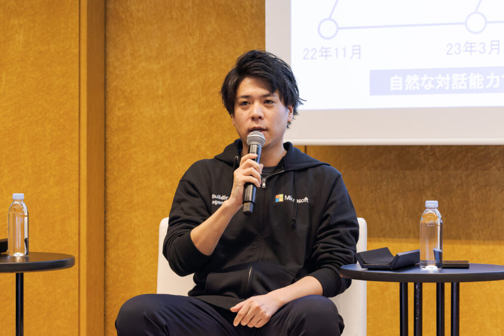 A man sitting in a chair holding a microphone