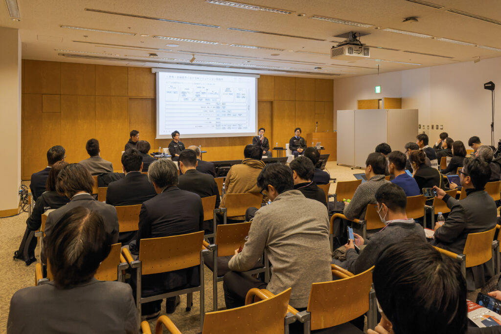 A group of people in a room with a screen