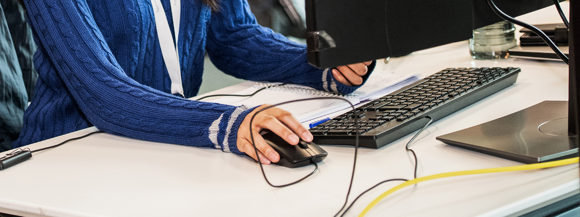 同僚と会話しながらデジタルタブレットを操作する男性