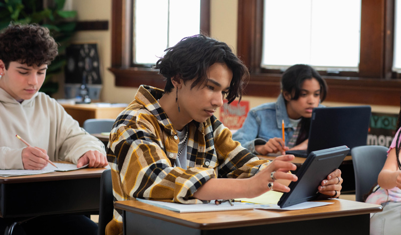 um homem em frente a uma lousa com equações matemáticas falando para um celular em um tripé