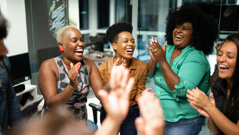 Homem lendo jornal em casa enquanto está em pé perto da janela.