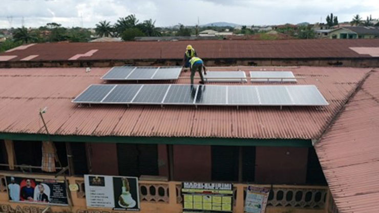 Two Man in engineering gear working with solar panels on a brown roof